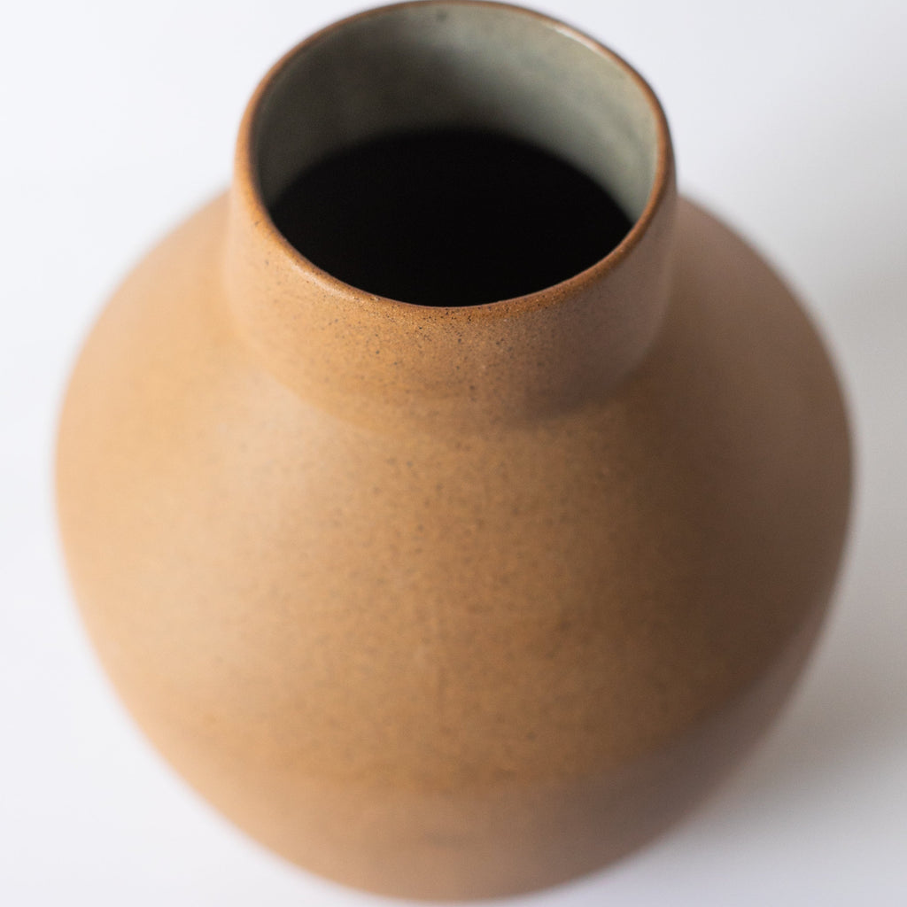Al Centro terracotta vase showing its open neck and natural clay tones
