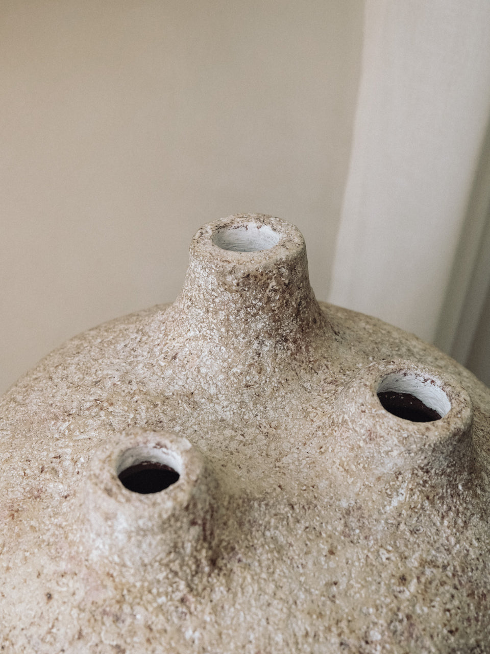 Close view of the three spouts and rough textured surface of the Amit terracotta vessel