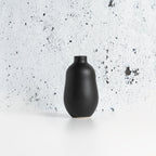 Black Gharyan stoneware vase on a speckled gray surface