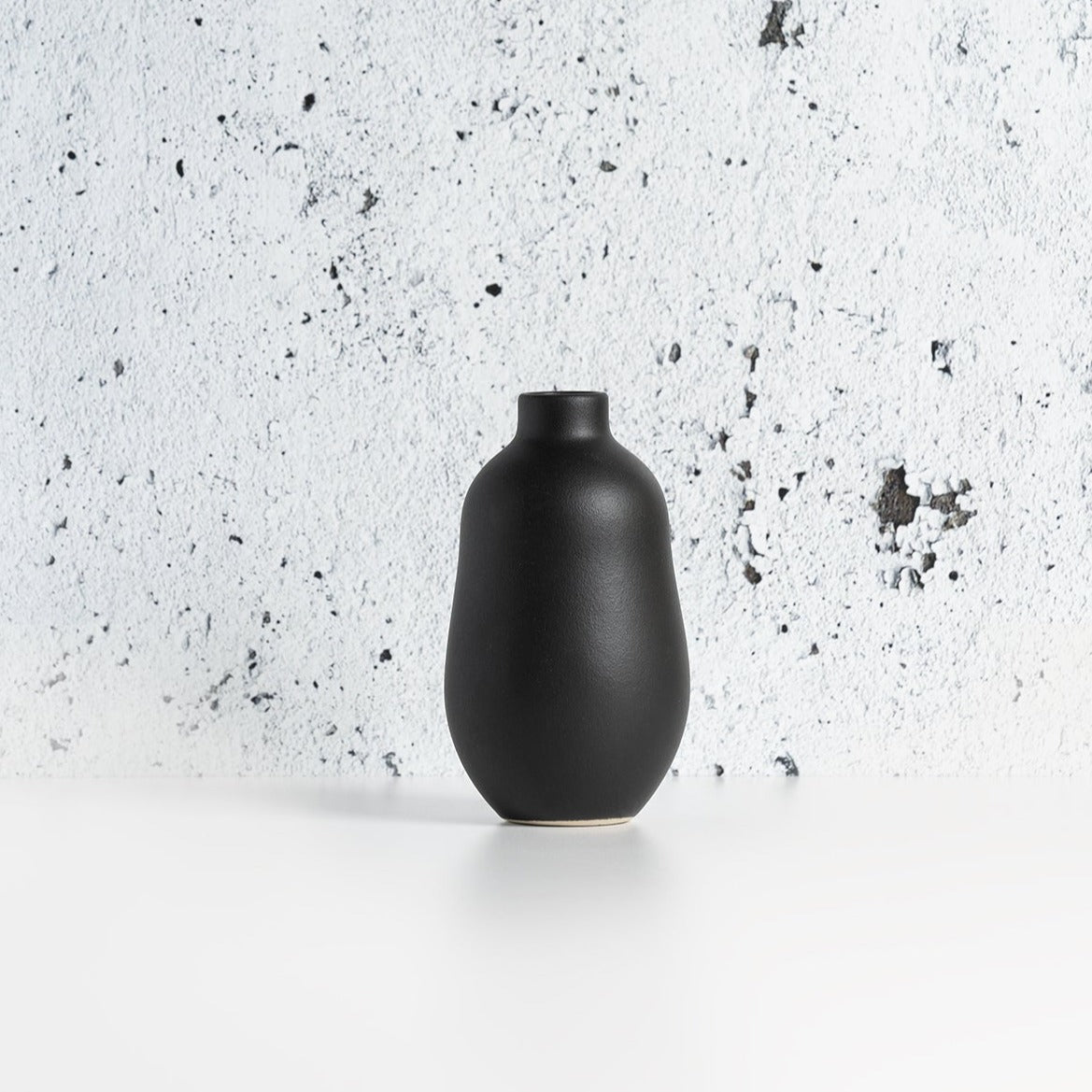 Black Gharyan stoneware vase on a speckled gray surface