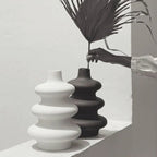 Black and white Mezo ceramic vases styled together with a dried palm leaf