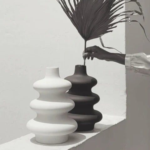 Black and white Mezo ceramic vases styled together with a dried palm leaf