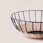 Cabo rattan basket side view showing low wide form and iron frame base — Calmly Elevated