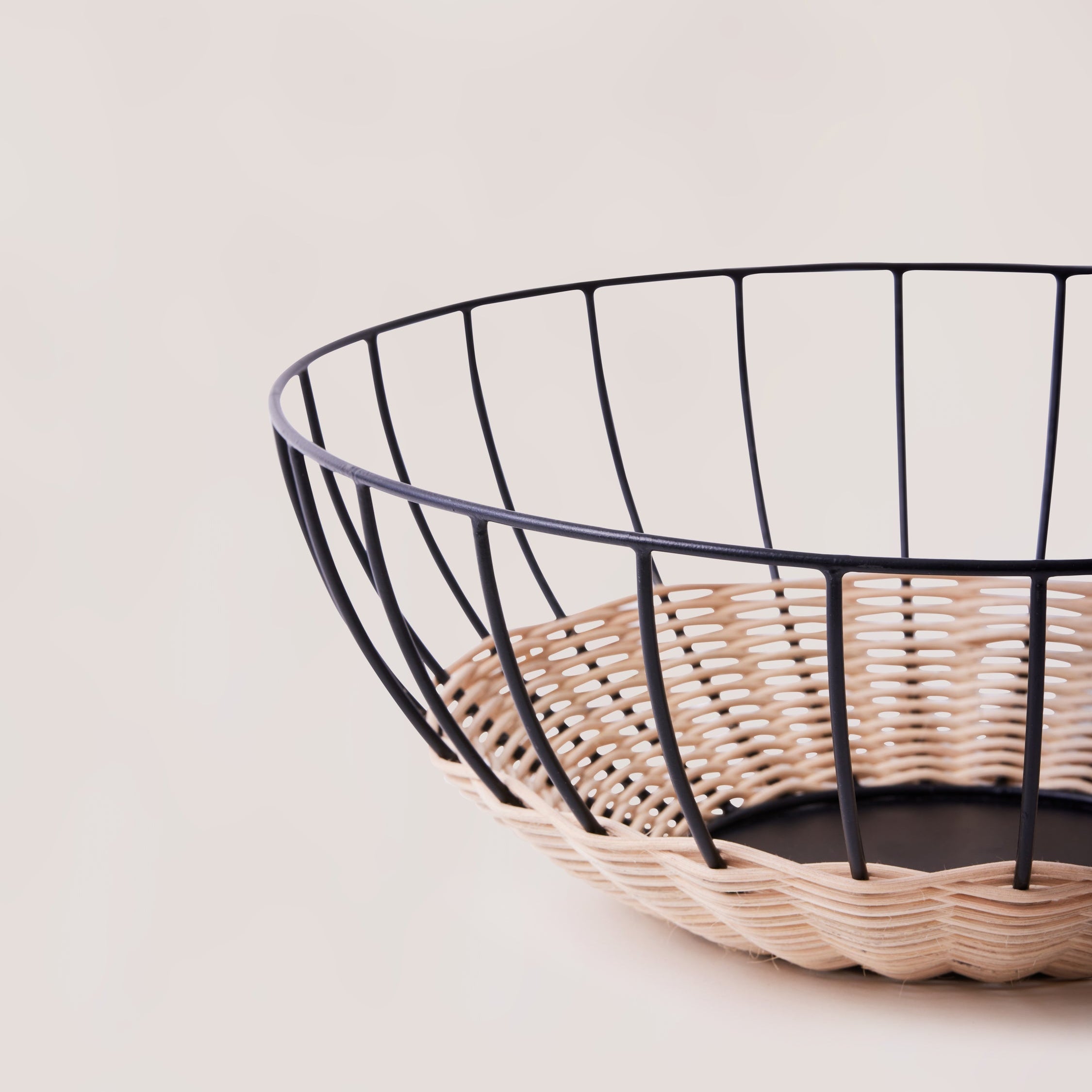 Cabo rattan basket side view showing low wide form and iron frame base — Calmly Elevated