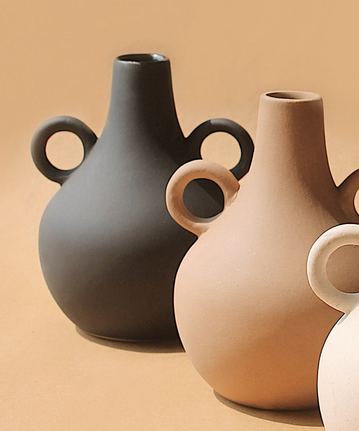 Charcoal and cream Harappan jug vases paired on a tan background