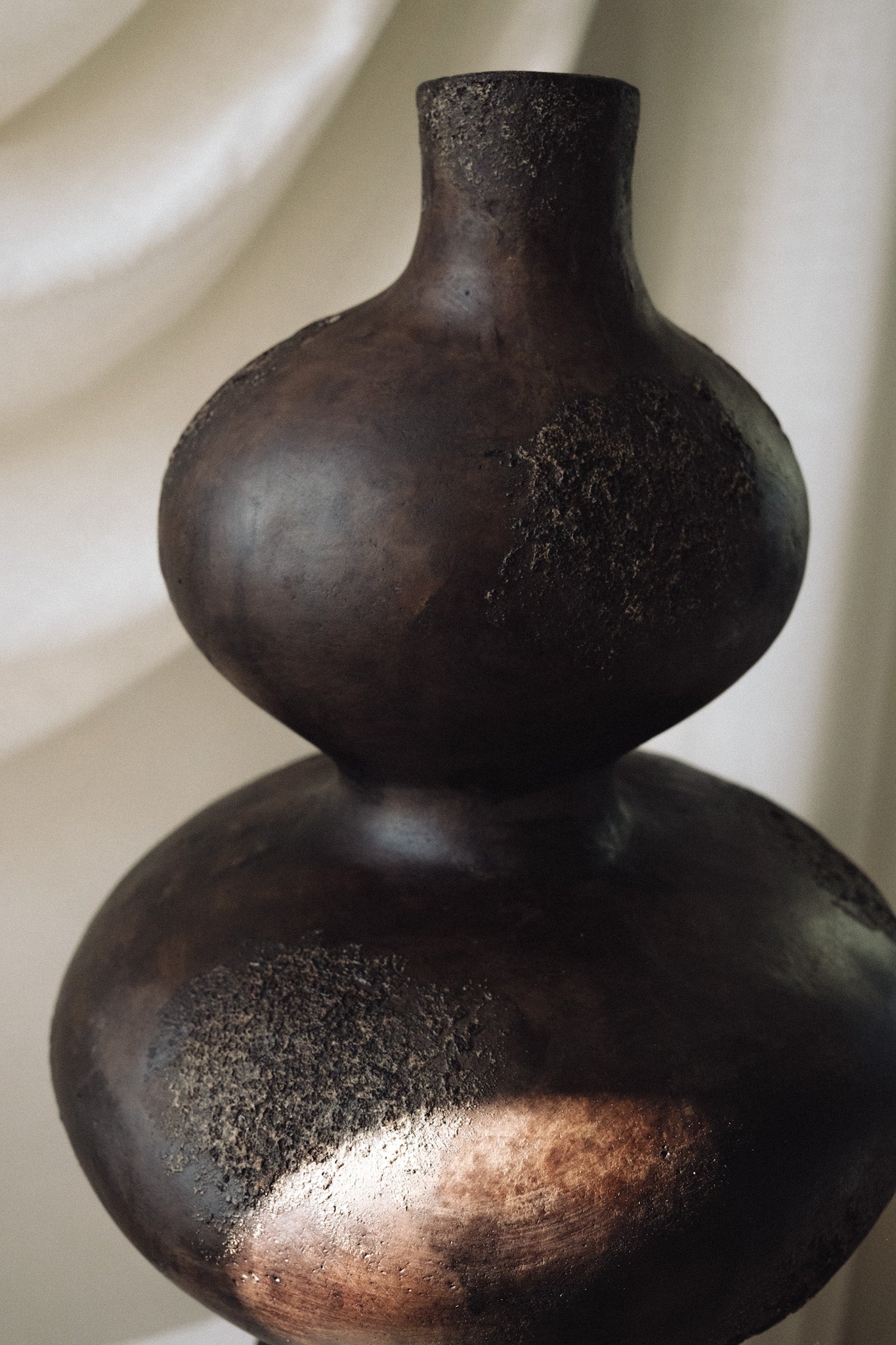 Close up of Sewu vessel showing textured dark brown glaze and rounded sculptural top