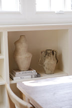 Cream terracotta Suma vessel styled with pottery and books in a built-in shelf