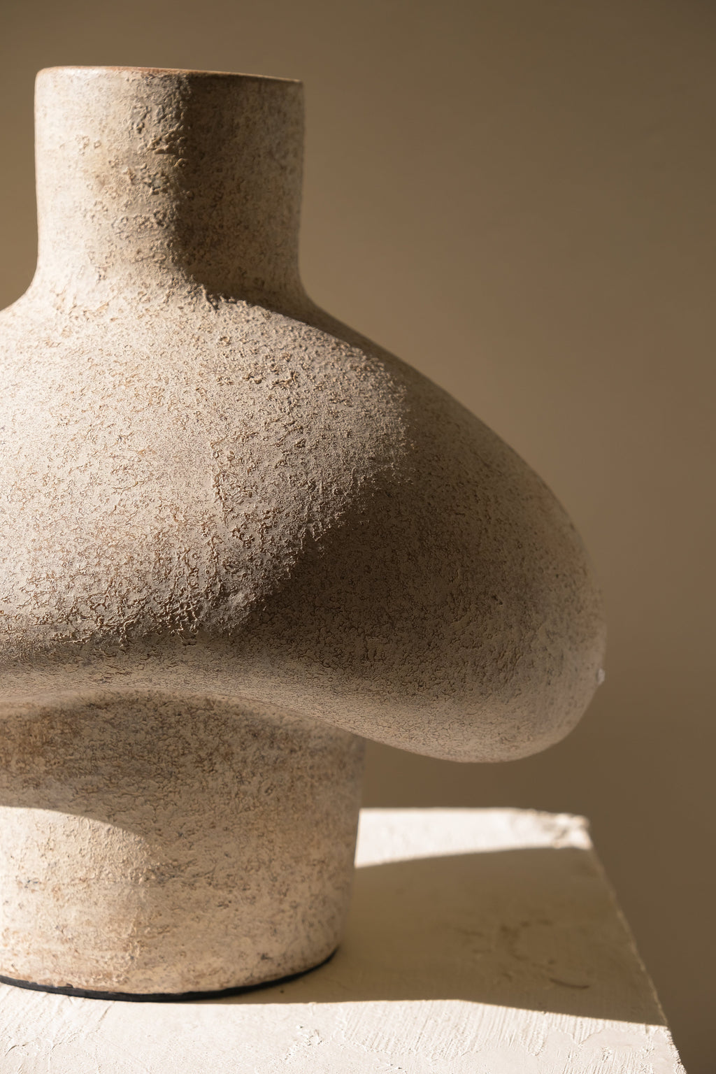 Cream terracotta sculptural vase with rounded hut like silhouette and matte finish
