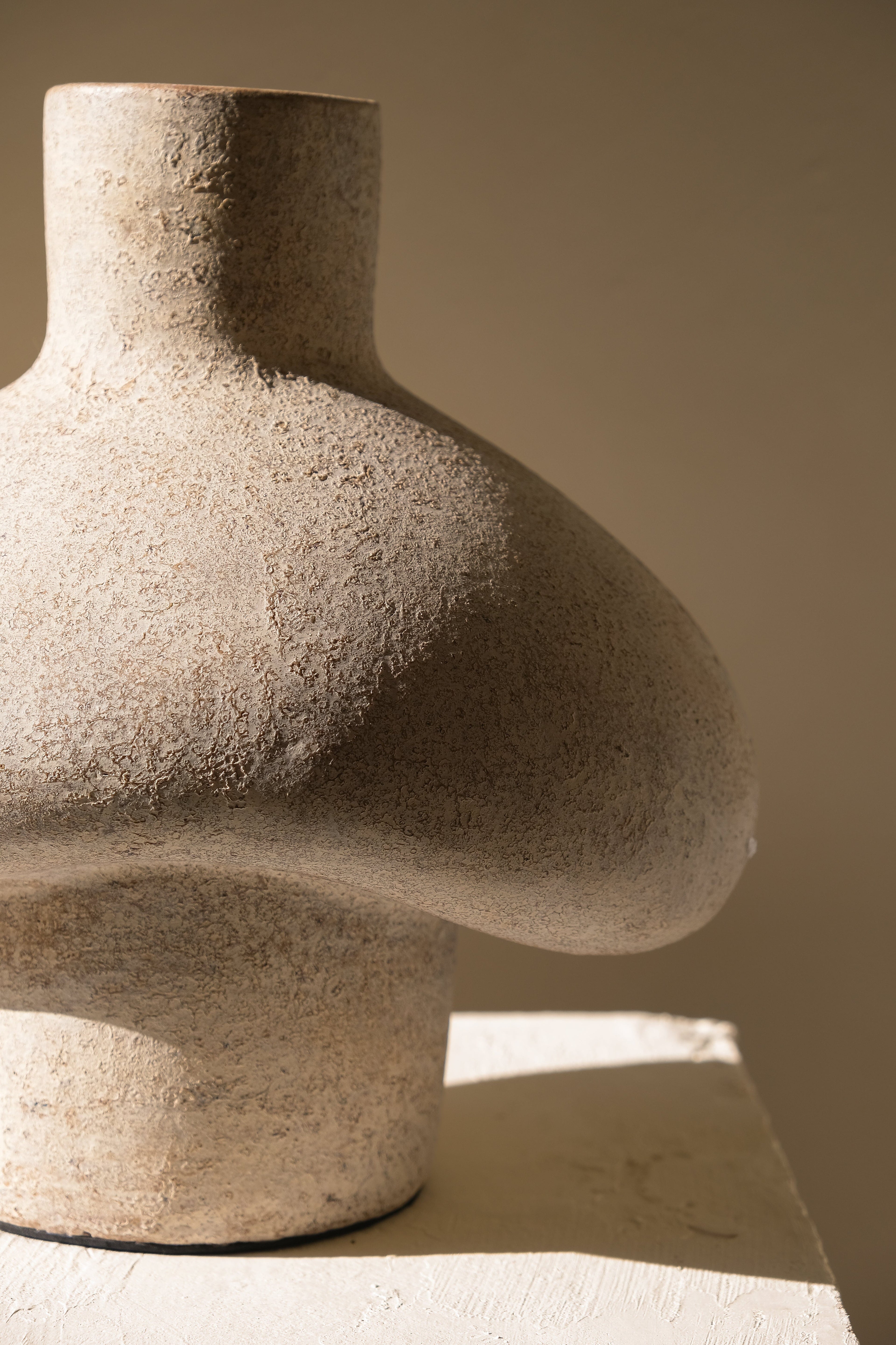 Cream terracotta sculptural vase with rounded hut like silhouette and matte finish
