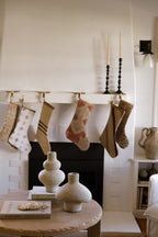 Cream terracotta vase styled on a console beside a decorated fireplace