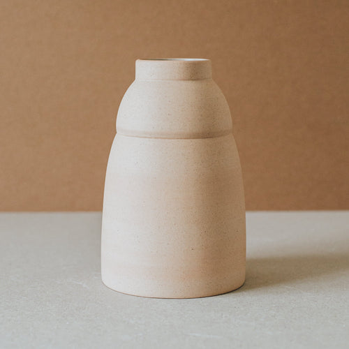 Handcrafted Chubby vase by Al Centro with a rounded stepped body in light terracotta on a stone surface