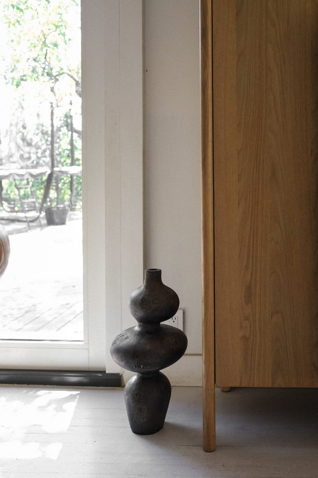 Sewu vessel placed beside a wood cabinet in a natural light interior