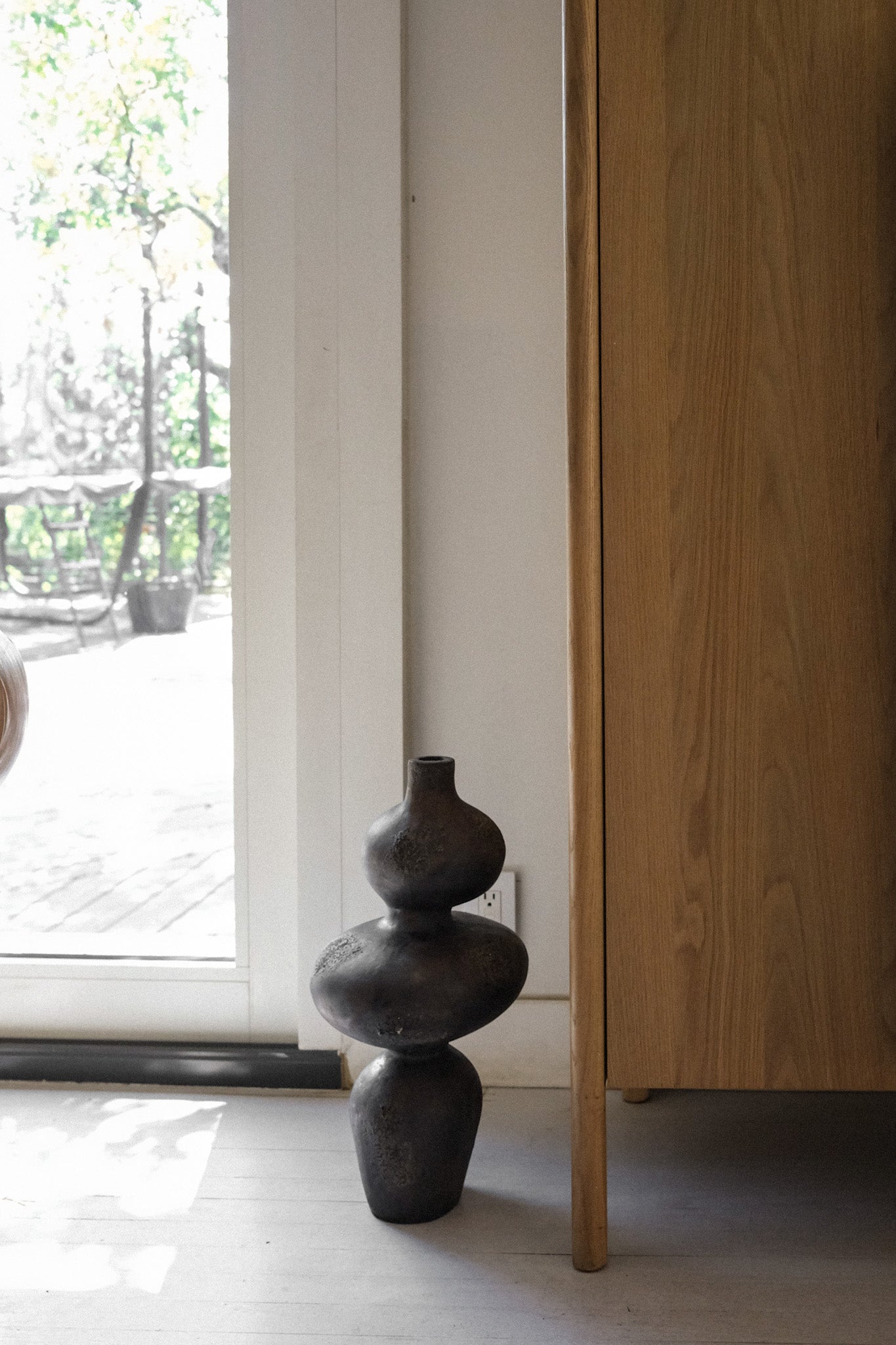 Sewu vessel placed beside a wood cabinet in a natural light interior