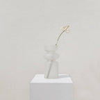 Iris frosted vase holding a single dried bloom on a white plinth