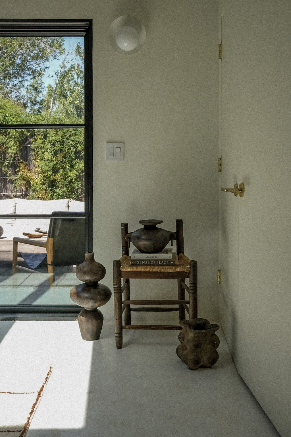 Sewu vessel grouped with terracotta pottery on a sunlit concrete floor