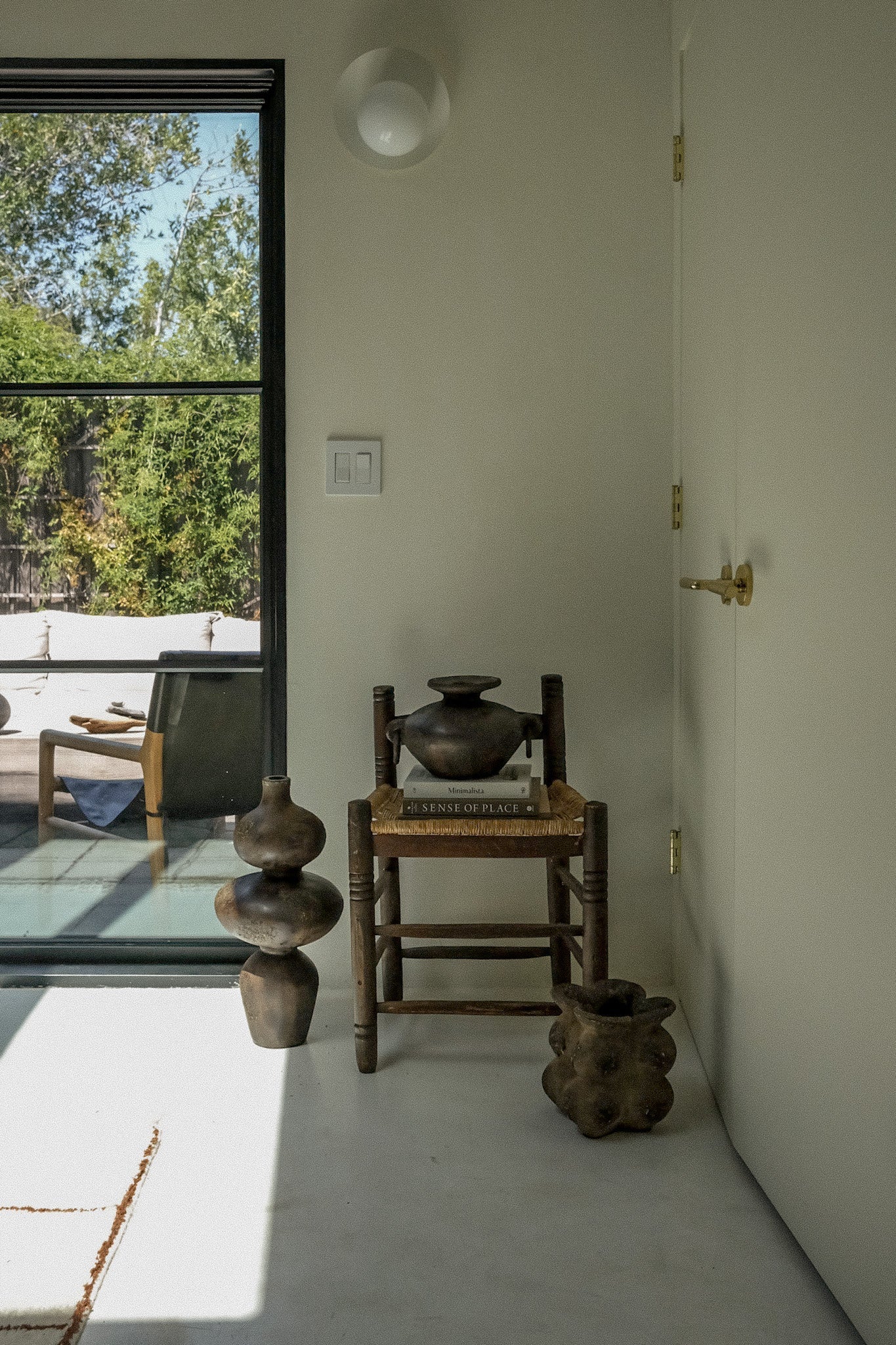Sewu vessel grouped with terracotta pottery on a sunlit concrete floor