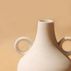 Soft cream Harappan vase showing its rounded form and slim neck