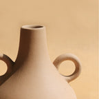 Soft cream Harappan vase showing its rounded form and slim neck