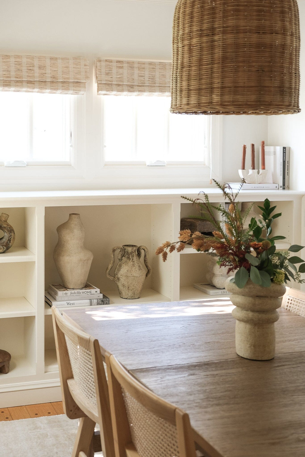 Suma vessel styled with books and florals on built-in shelves in a dining space