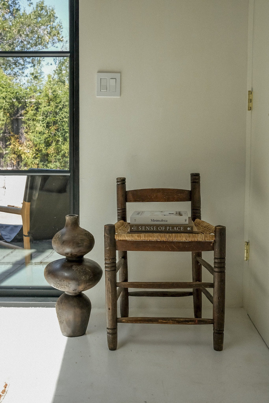 Tall terracotta sculptural vase styled in a bright open plan living space
