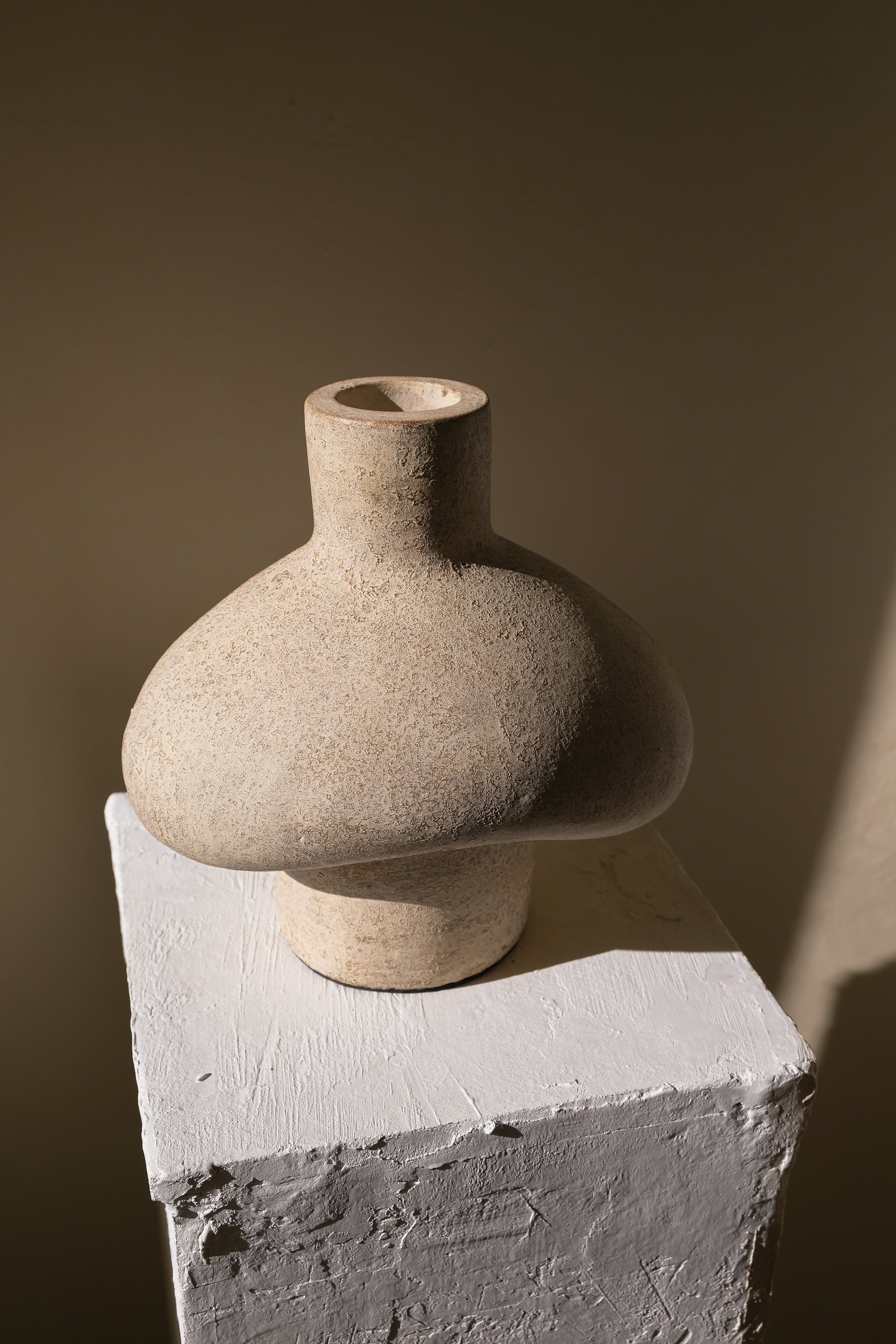 Tanah coastal vessel shown in profile on a white pedestal against a warm wall