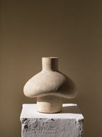 Tanah handmade terracotta vessel in textured shell white on a white plaster pedestal