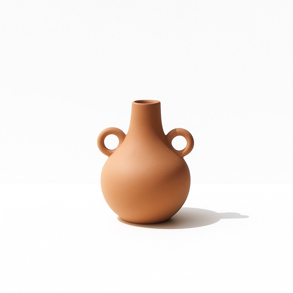 Warm terracotta Harappan vase with ring handle on a clean white background