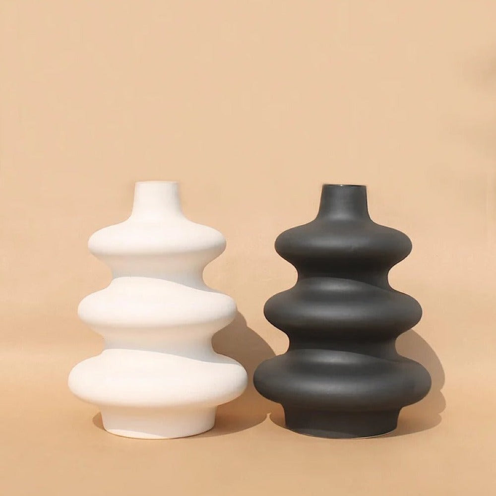 White and black Mezo tiered vases grouped on a tan background