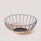 Cabo rattan basket showing low wide form and iron frame base — Calmly Elevated