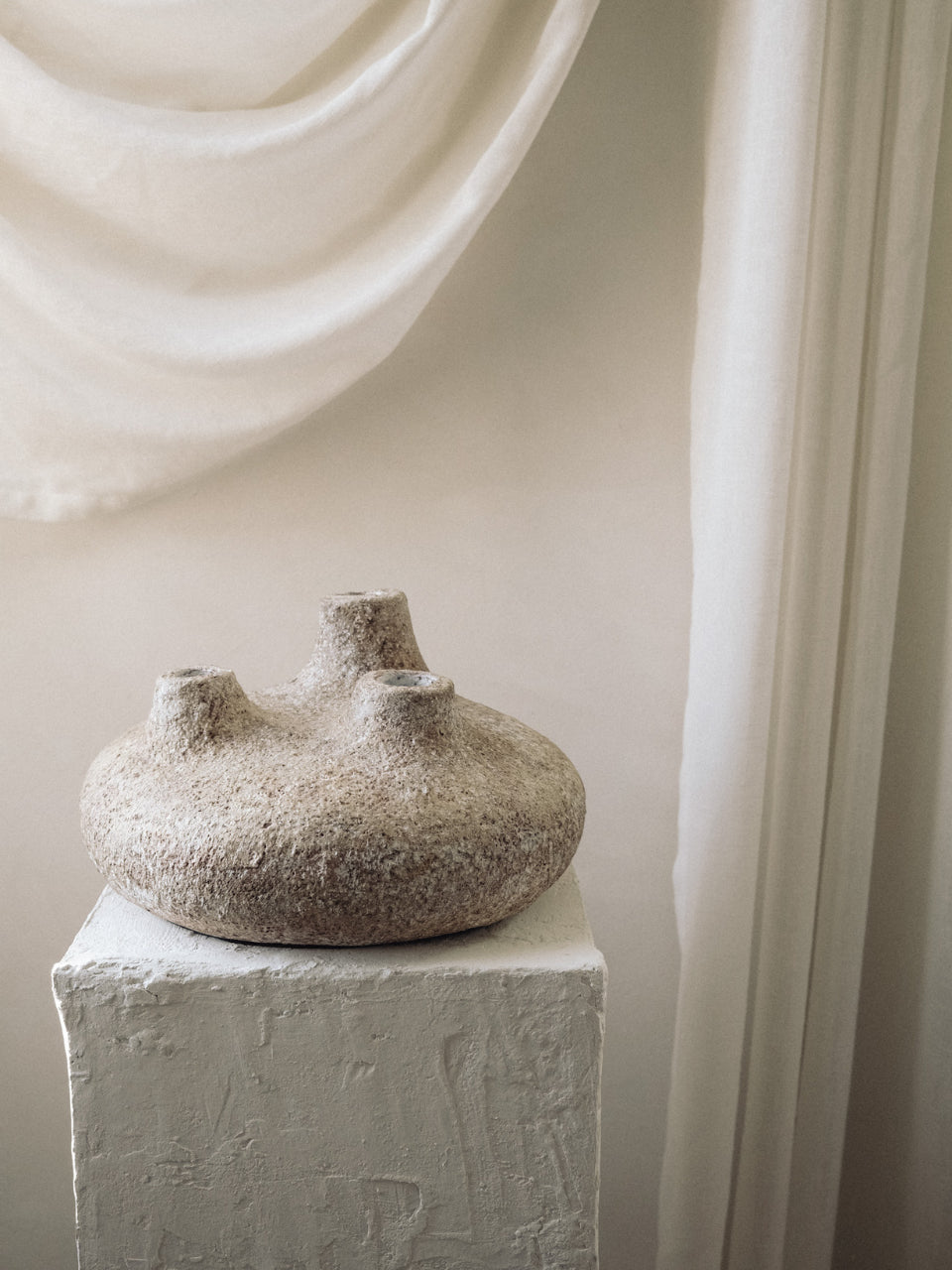 Low rounded Amit Vessel shown in profile on a plaster pedestal