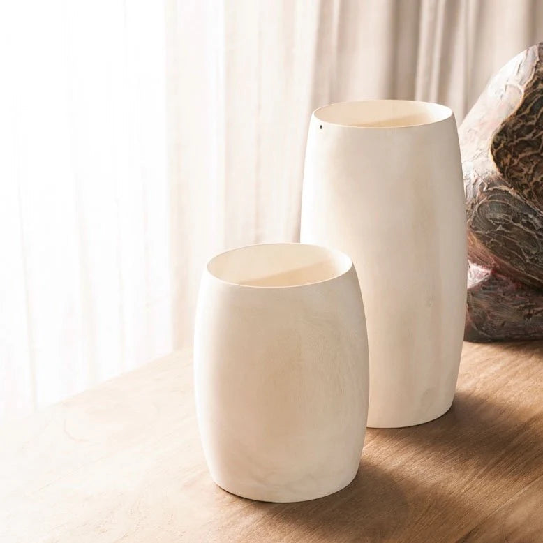Pair of sustainable wood vases in two sizes styled on a sunlit wood table